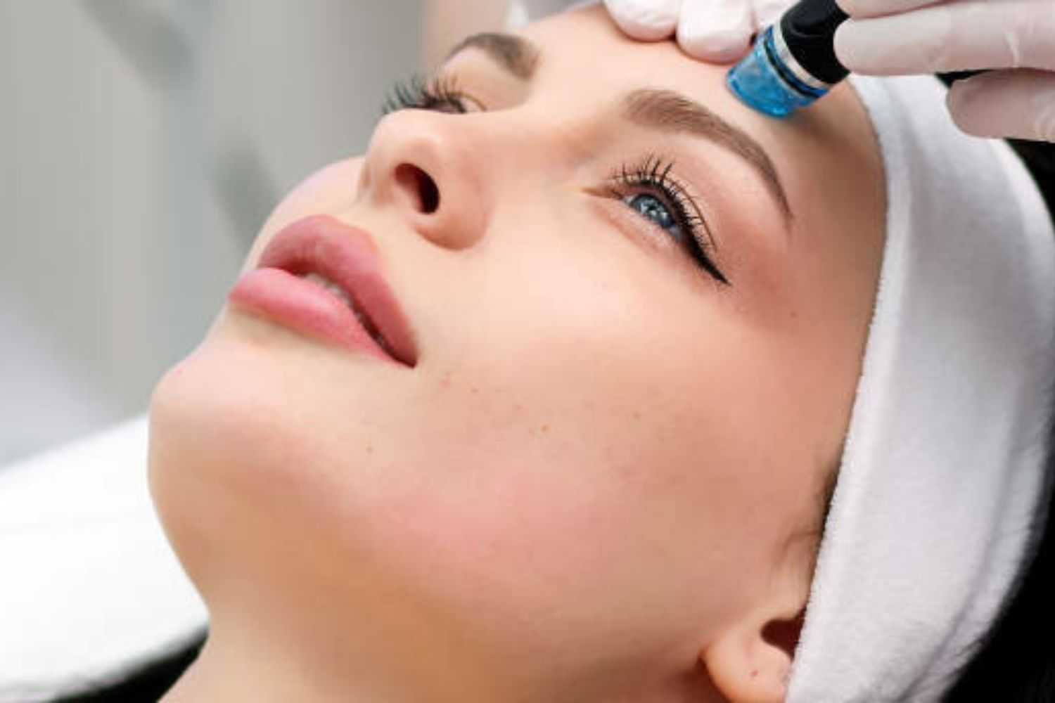 Facial treatment in progress, woman with a headband getting skincare procedure.