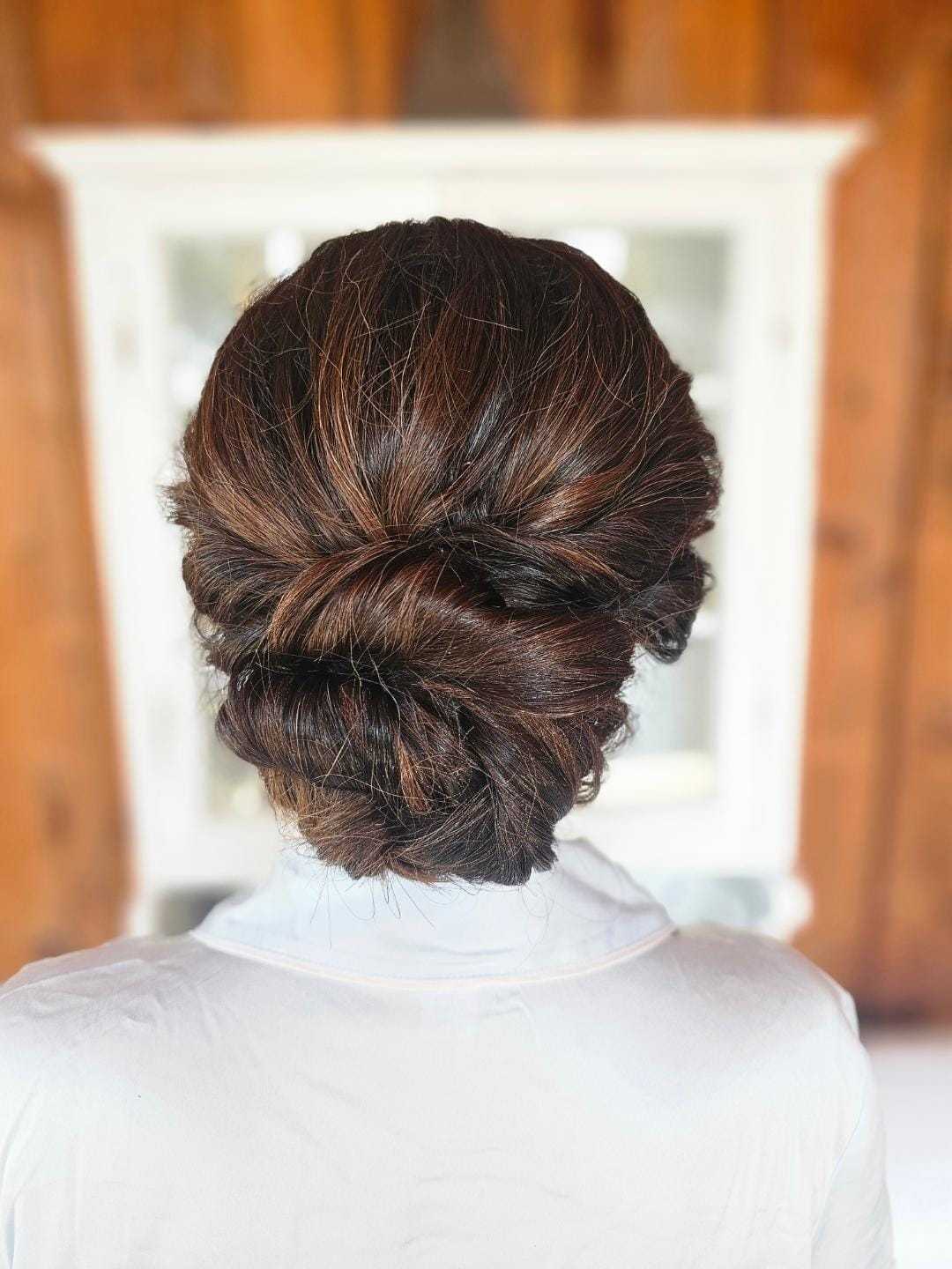 Sophisticated updo hairstyle on a blurred background, showcasing elegant hair arrangement.