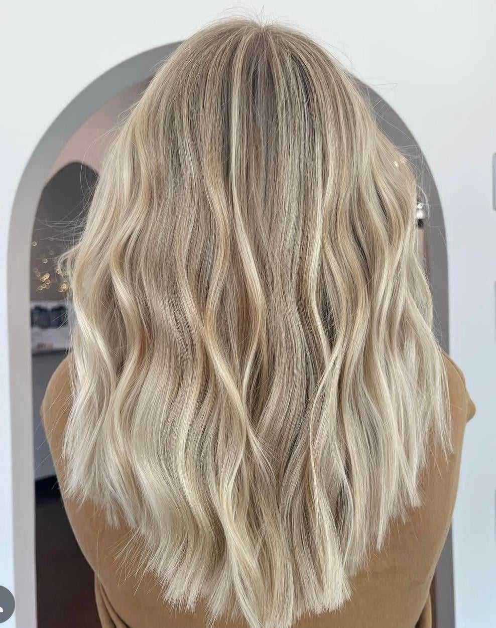 Wavy blonde hair styled with soft, natural curls.
