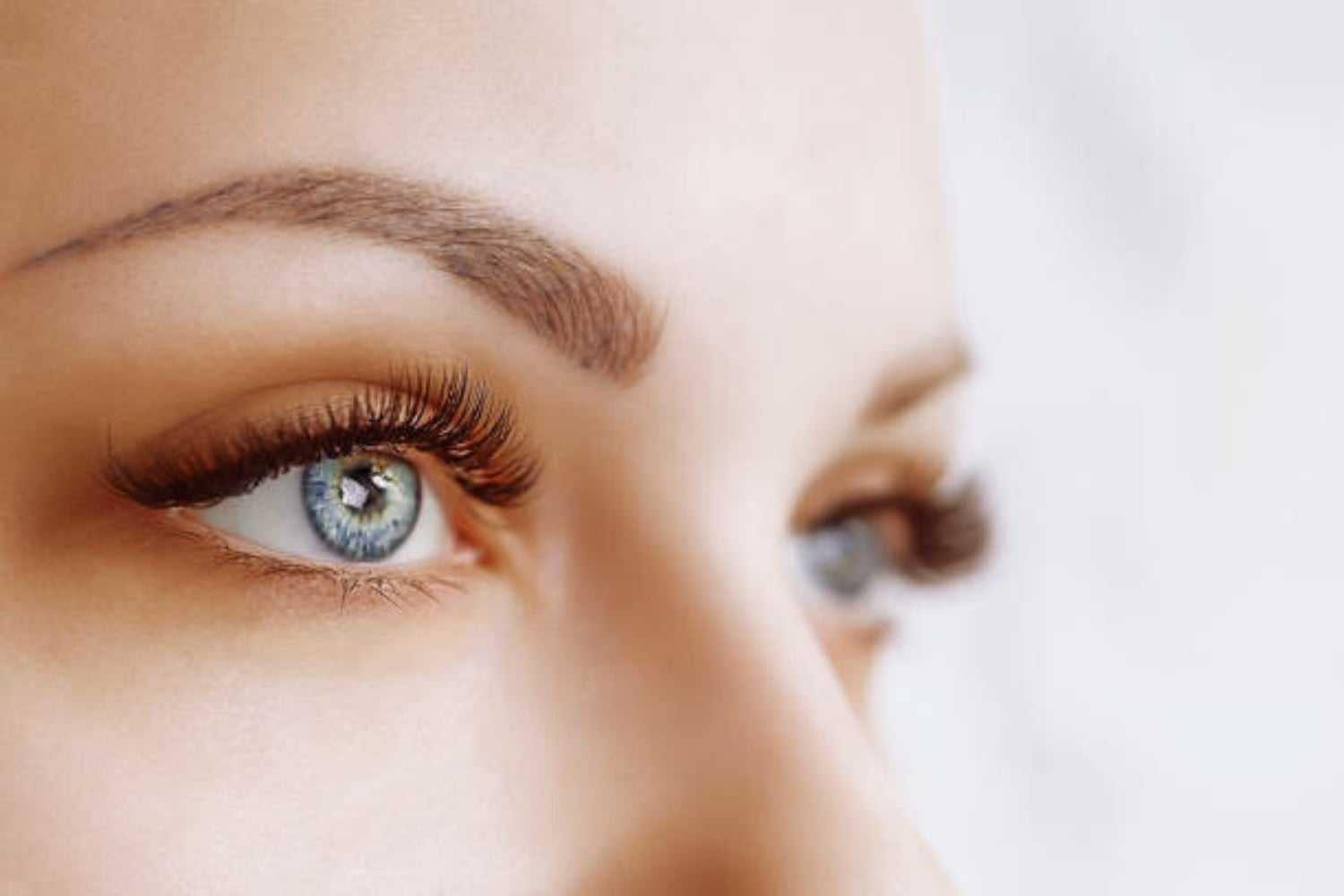 Close-up of a person's eyes with long eyelashes and well-defined eyebrows.