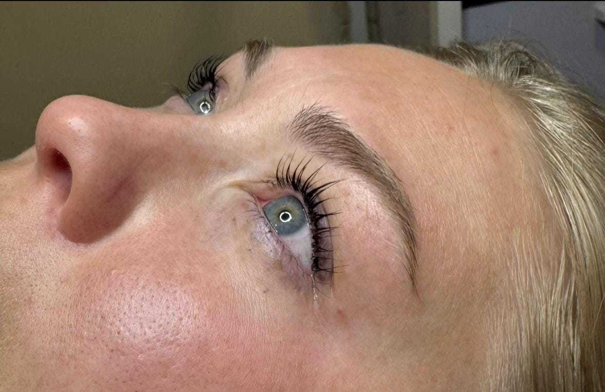 Close-up of a person's eyes, showcasing long eyelashes and well-groomed eyebrows.