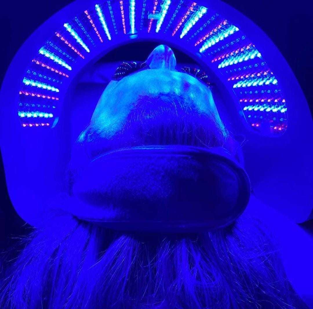 Person undergoing blue LED light therapy treatment.